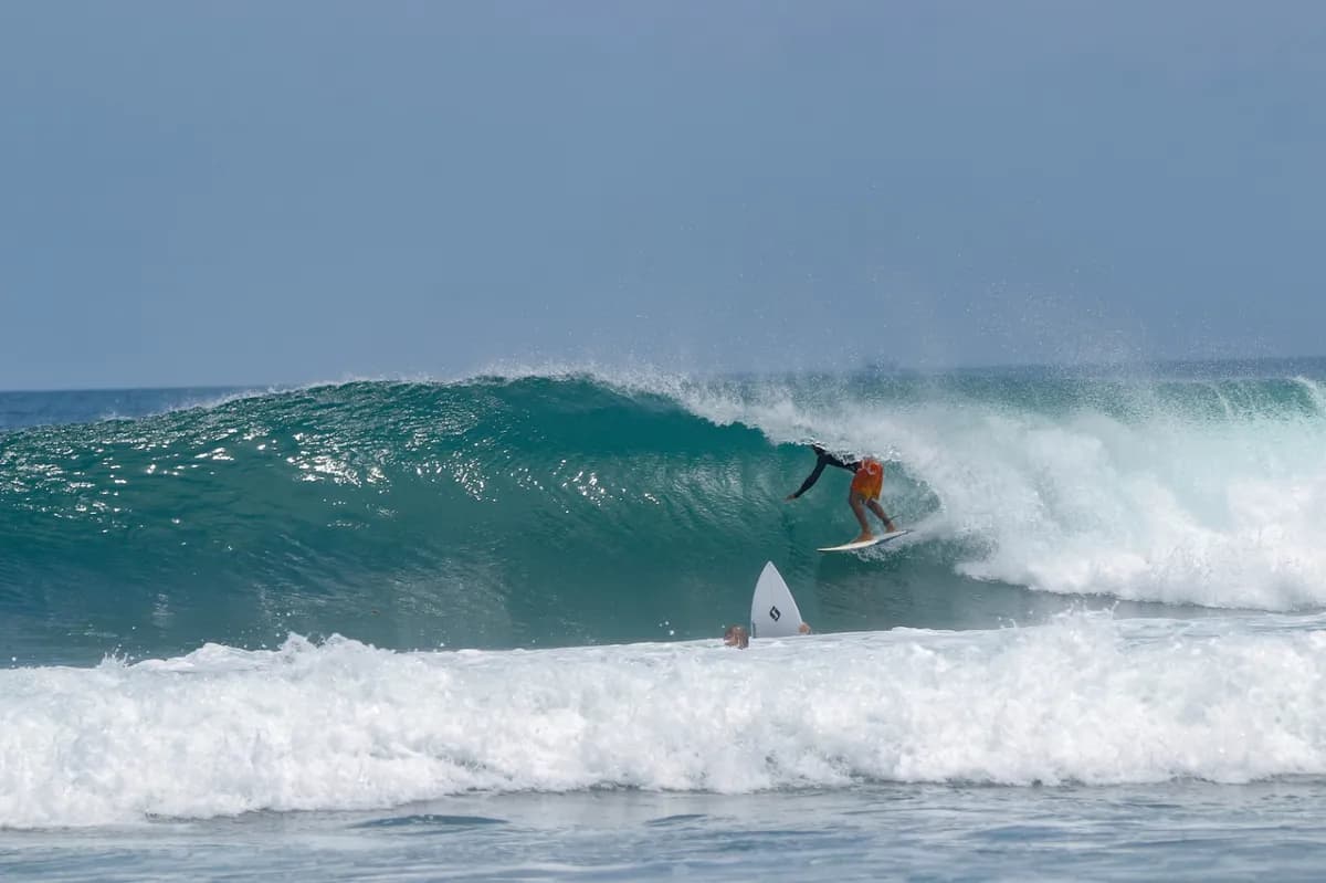 Surfer @jeynner-granado crouches inside a perfect wave barrel.