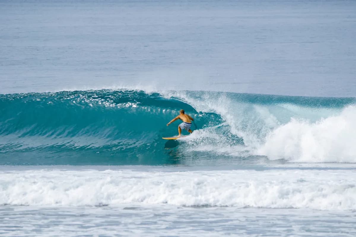Surfer rides inside a clear blue barrel at Playa Colorado.