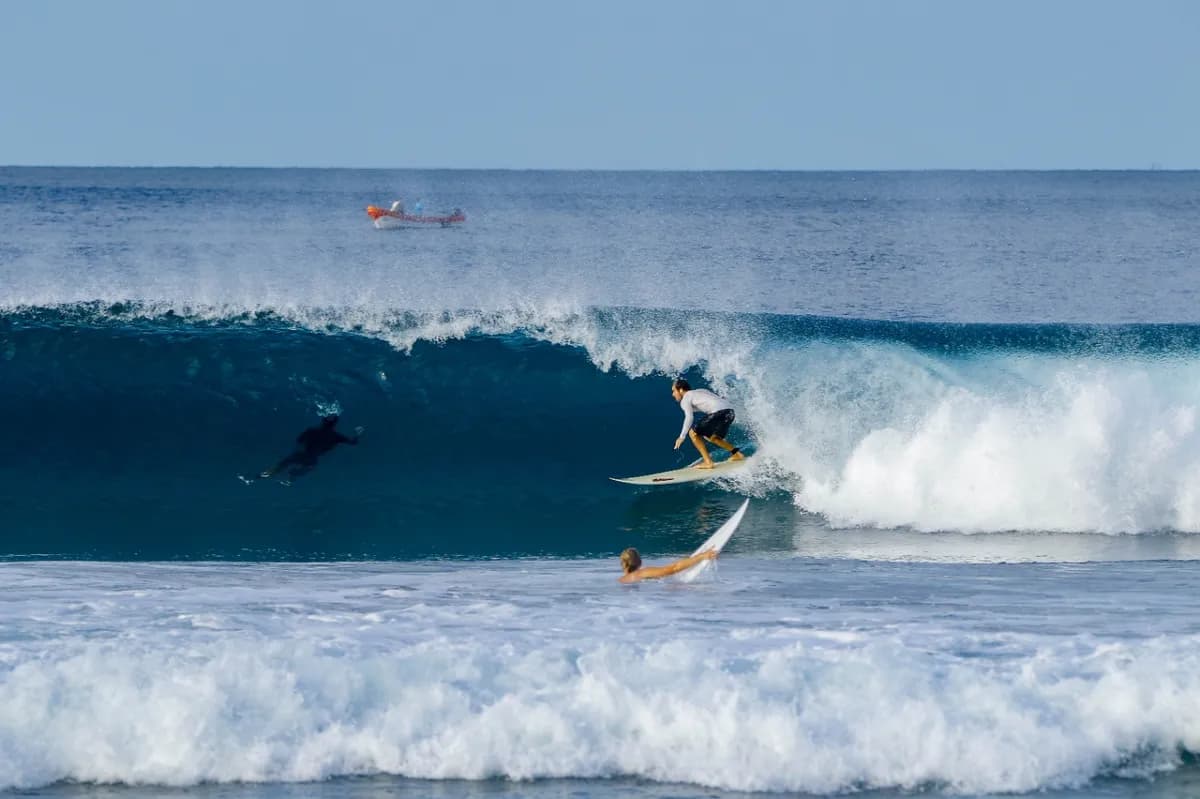 Surfer executing a powerful drop into a hollow wave.