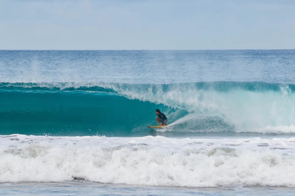 Surfer @swnnga disappears into a perfect turquoise barrel.