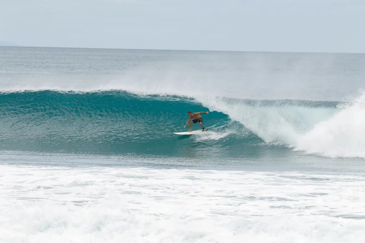 Surfer riding a hollow wave with perfect form.