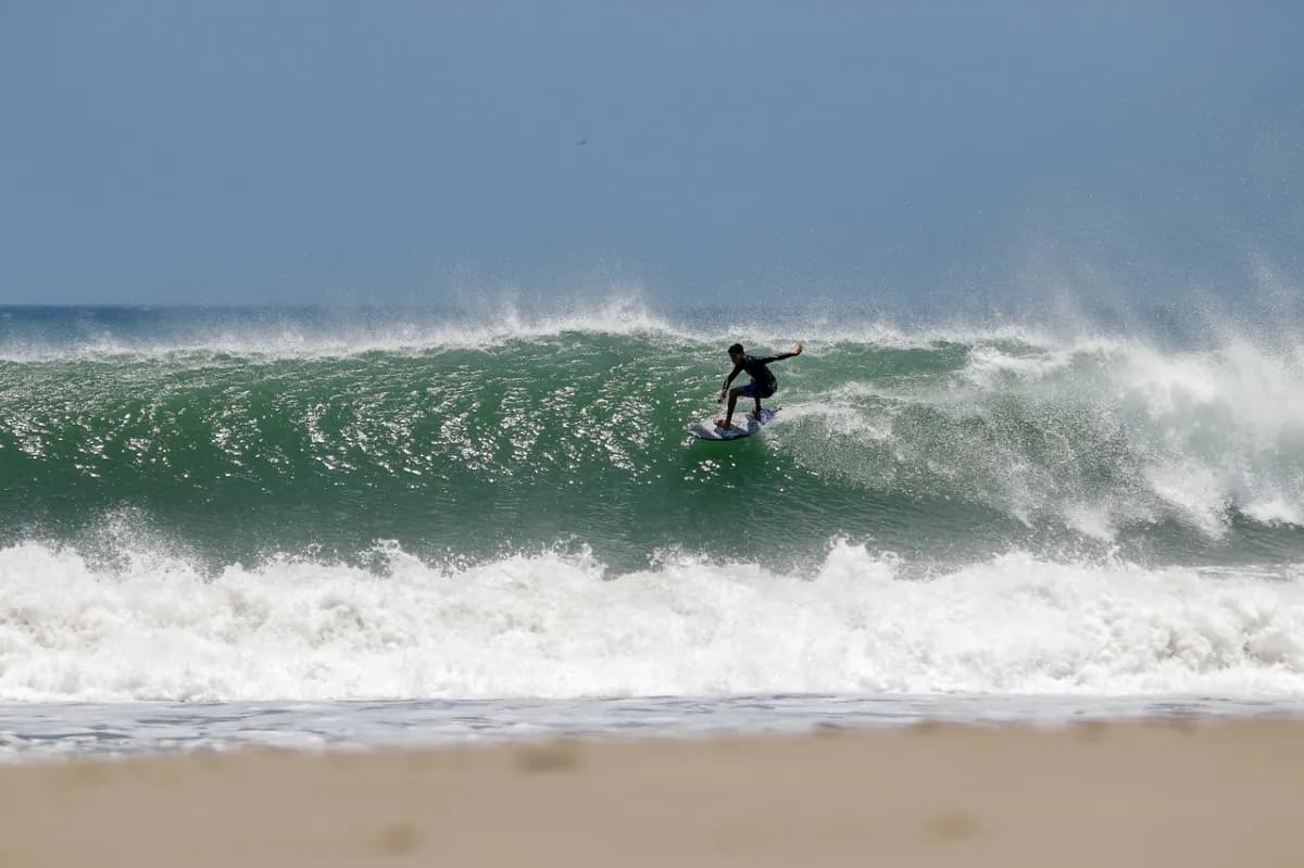 Surfer executing a clean bottom turn on a powerful wave.