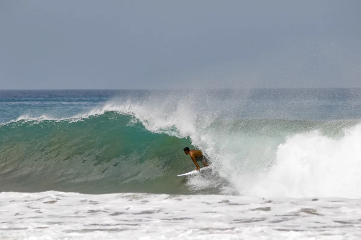 Surfer rides inside a powerful barrel wave.