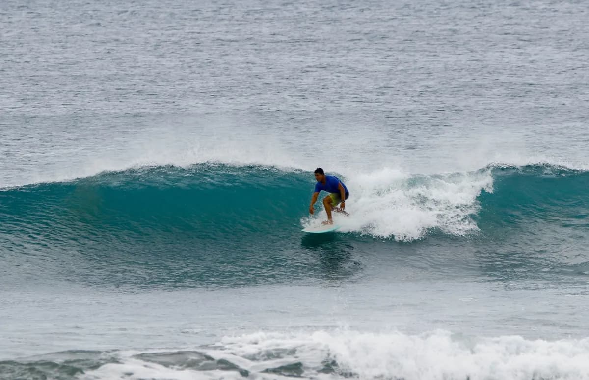 Surfer @heyner-obando rides a small, peeling wave at Panga Drops.