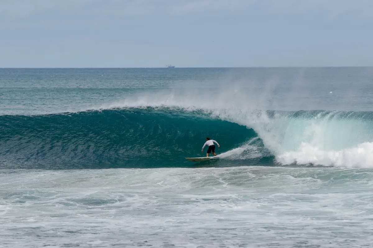 Surfer rides deep barrel wave at Playa Colorado.