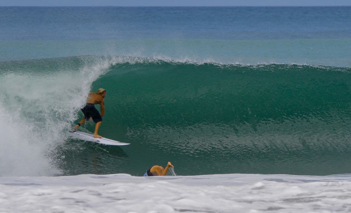Surfer rides inside a perfect green barrel.