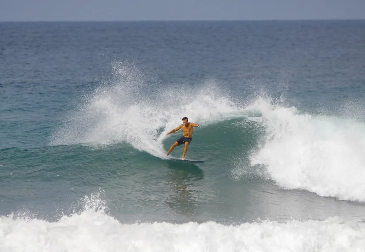Surfer carves sharply on a crashing wave.