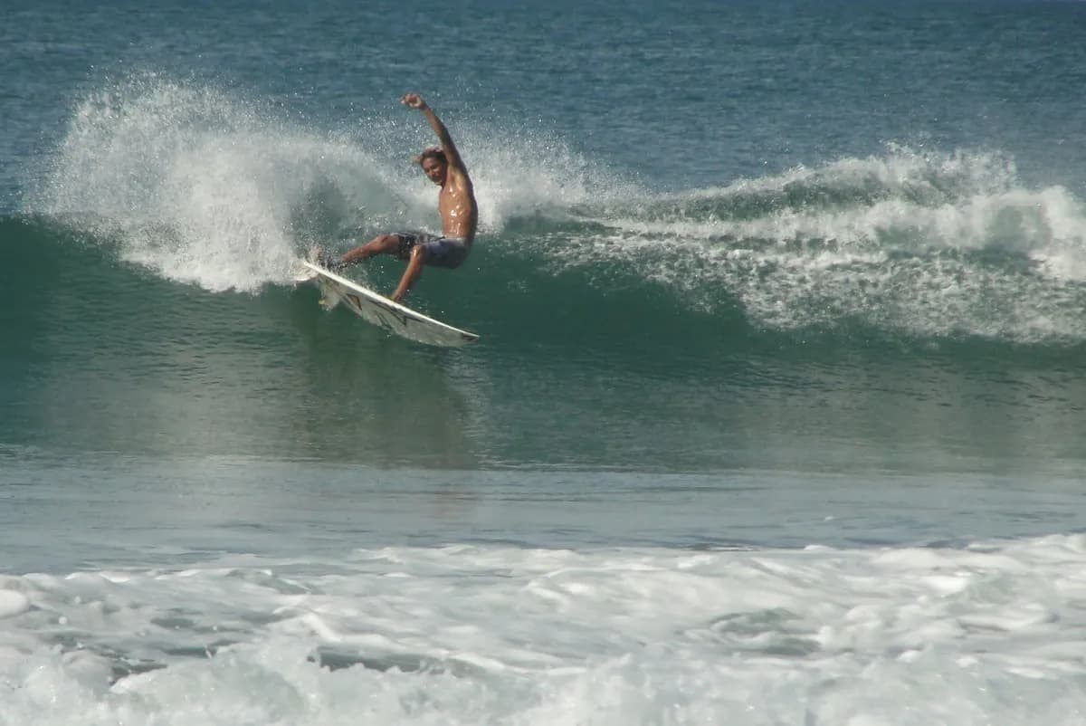 Surfer carves a sharp turn spraying water around.