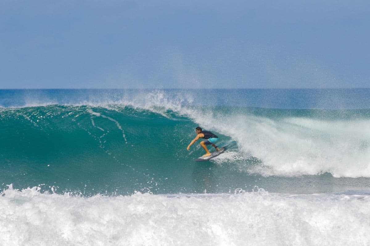 Surfer rides inside a clear glassy barrel.