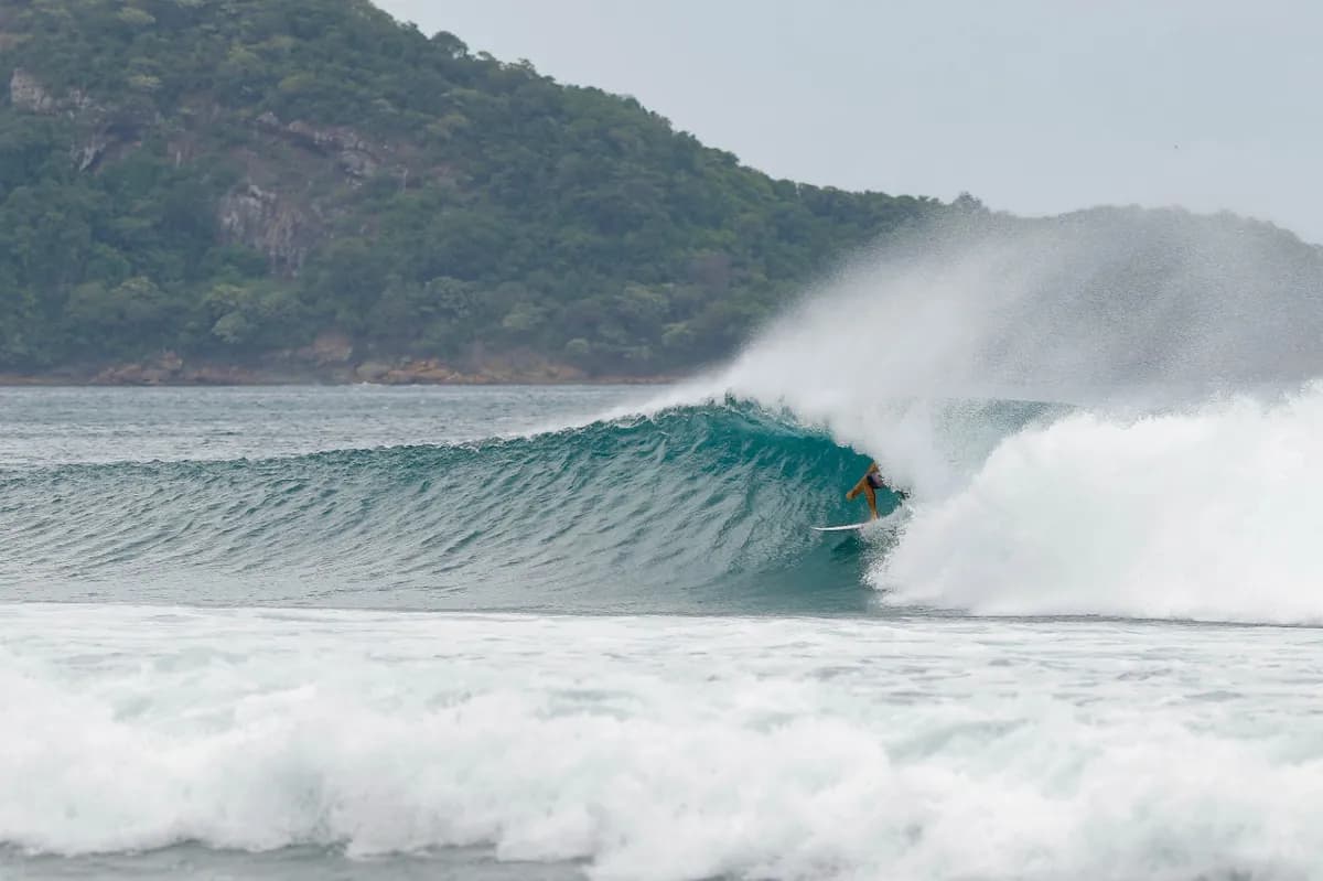 Surfer @diego-galazar rides smoothly inside a crystal-clear barrel.