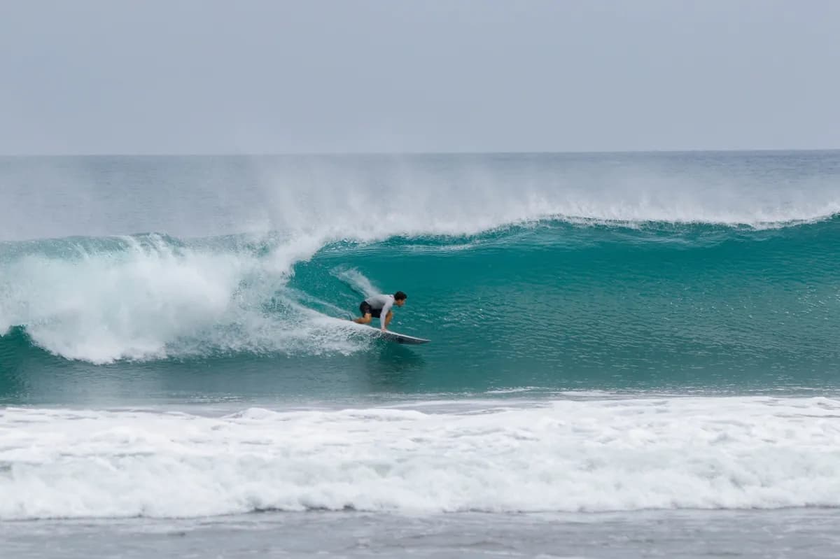 Surfer rides a clean right-hand wave in perfect form.