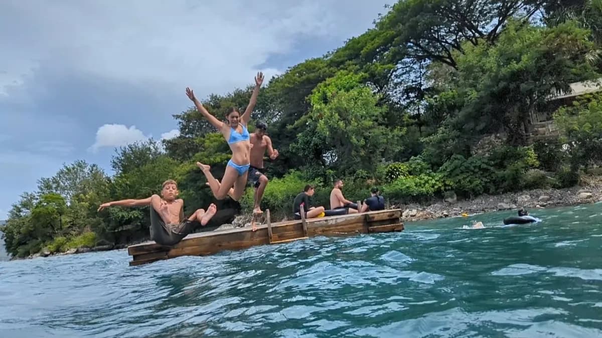 Group jumping off a dock into the water.