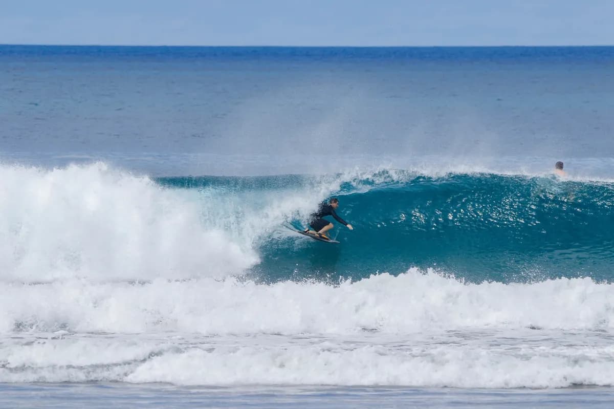 Surfer rides inside a perfect turquoise barrel.
