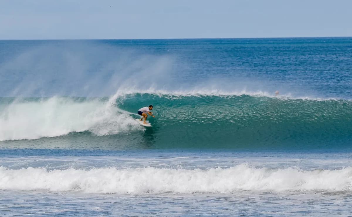 Surfer skillfully rides inside a perfect barrel wave.
