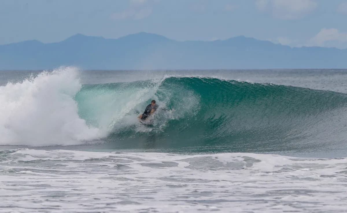 Surfer rides inside a perfect barrel wave.