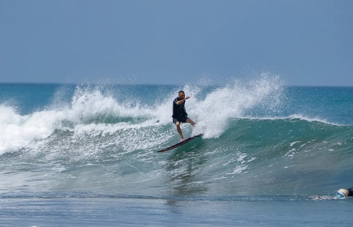 Surfer executes a bottom turn on a small right wave.