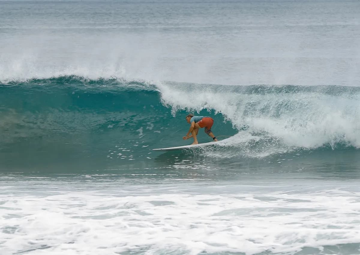 Surfer rides a perfect barrel wave with style.