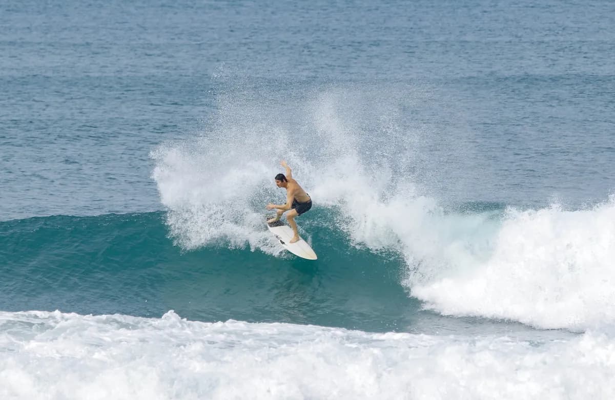 Surfer executes a powerful cutback on a blue wave.