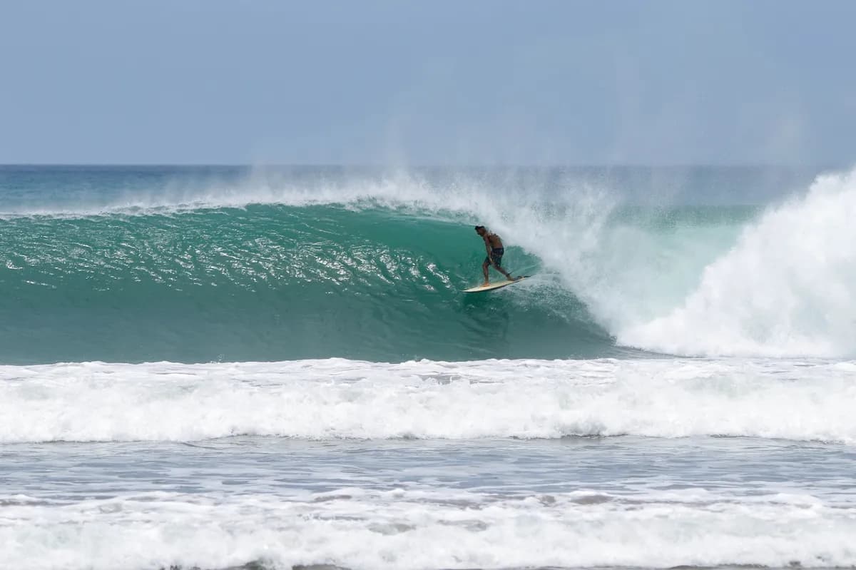 Surfer riding a perfect barrel wave at Playa Colorado.