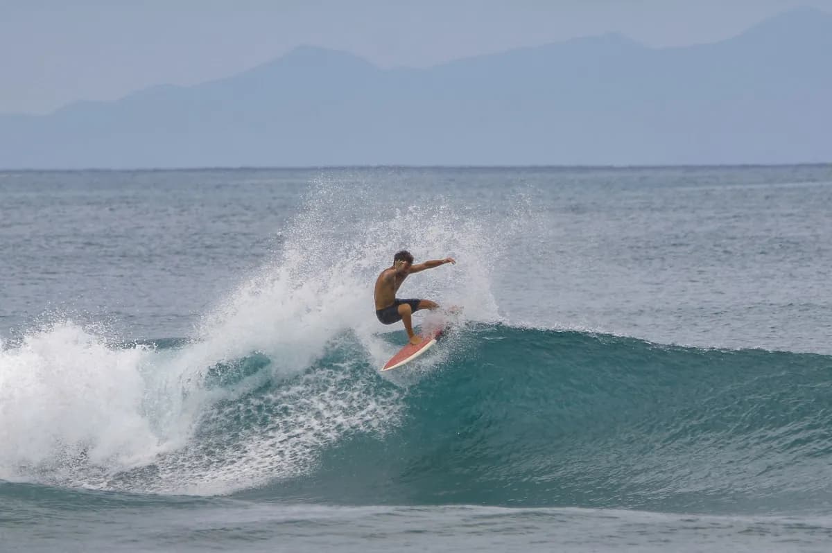 A surfer executes a stylish cutback on a peeling wave.