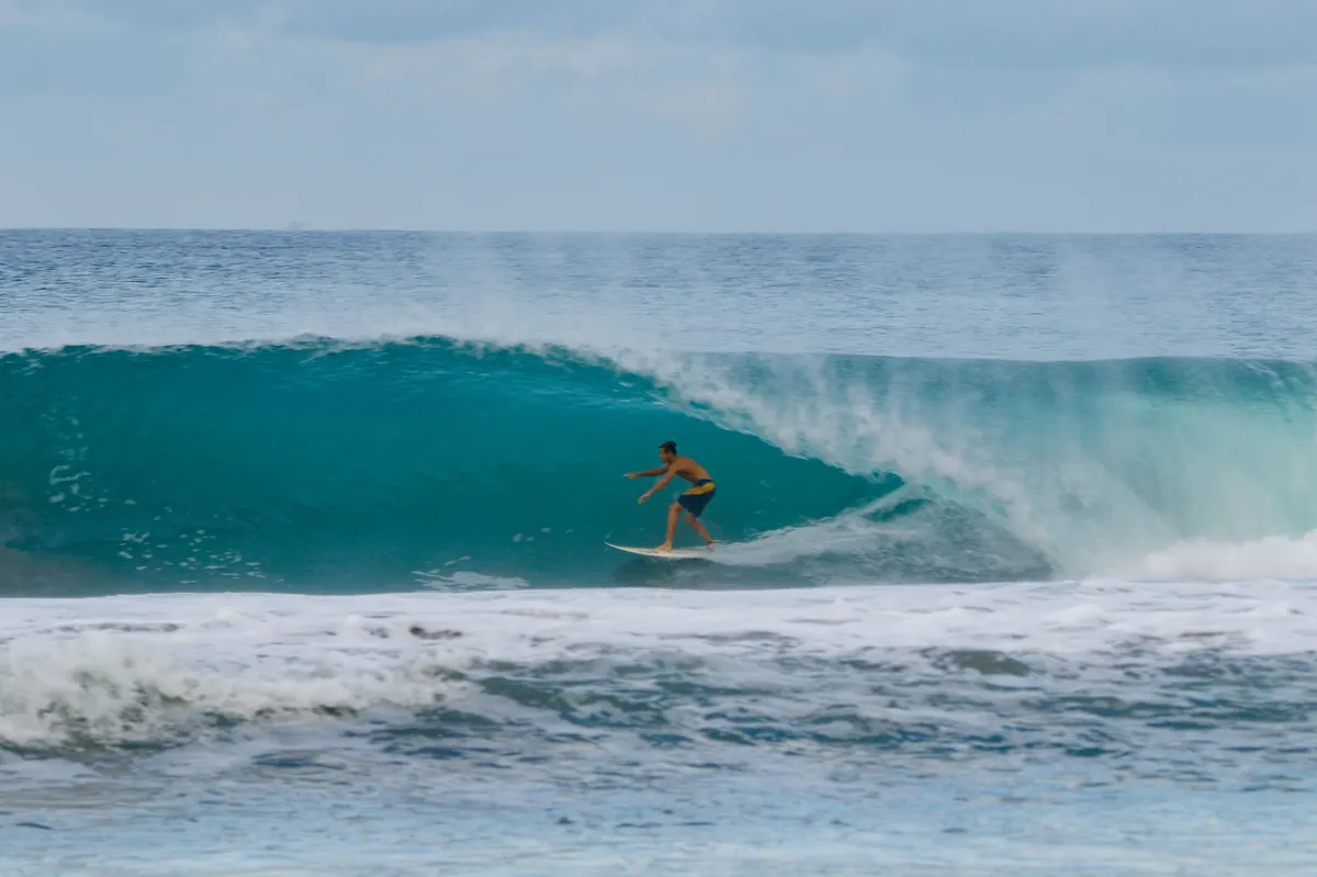 Surfer rides a perfect barrel wave at Playa Colorado.