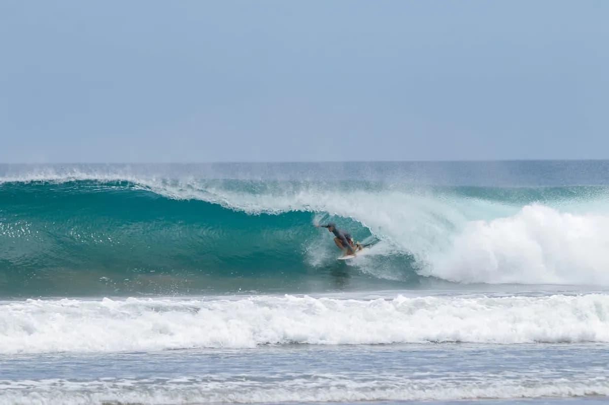 Surfer skillfully riding a barreling wave at Playa Colorado.