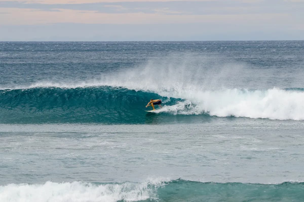 Surfer skillfully rides a hollow wave, tucked inside the tube.