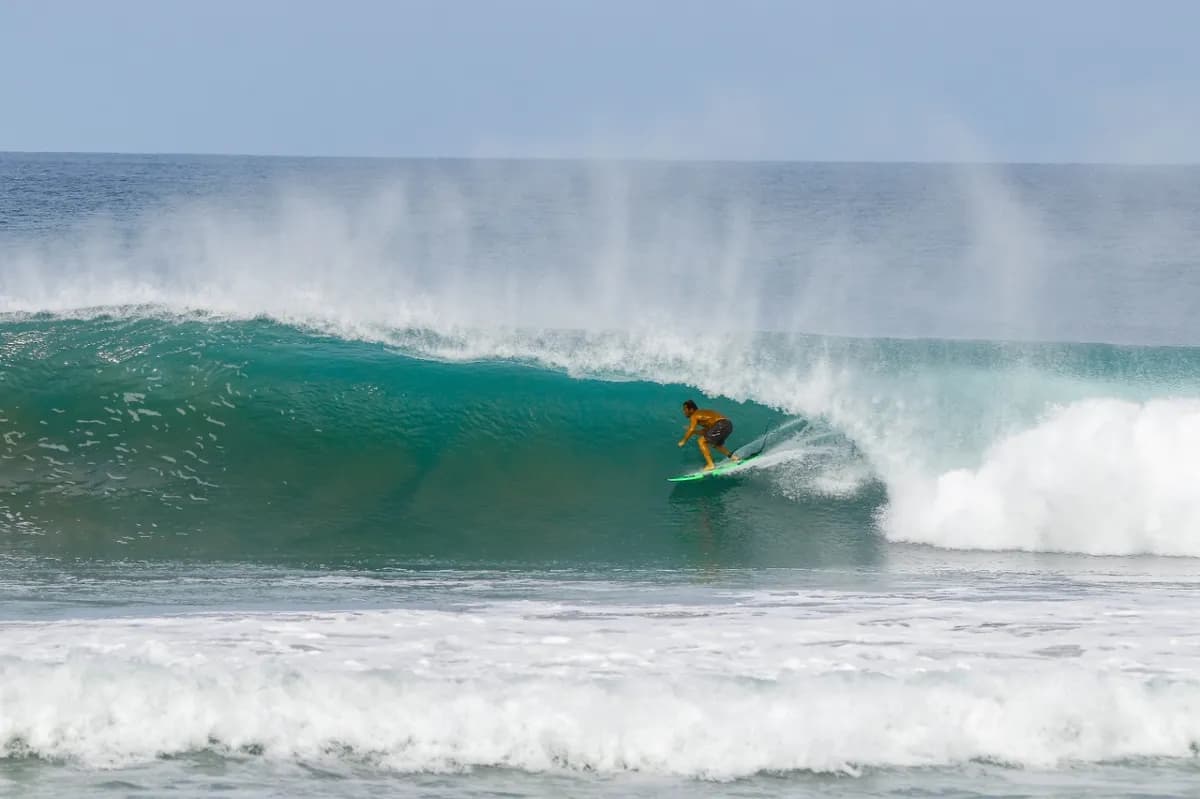 Surfer inside a perfect, turquoise barrel with clean lines.