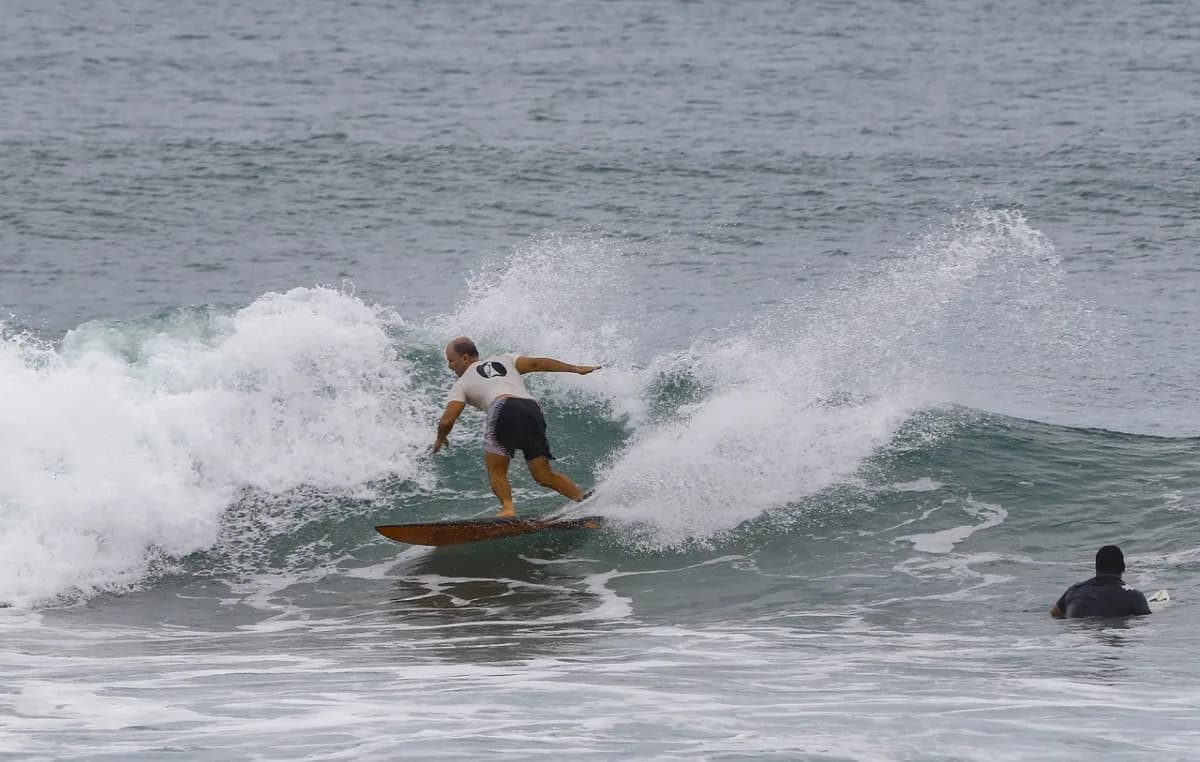 Surfer executing a dynamic cutback on a small wave.