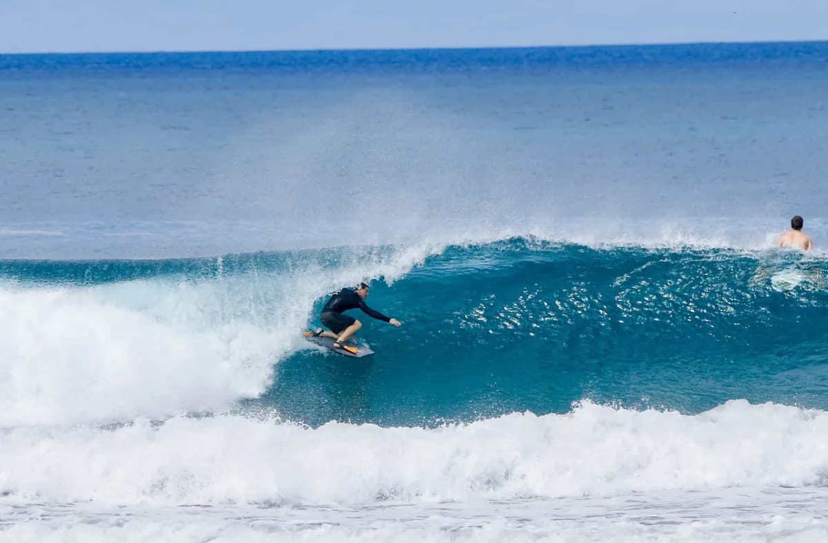 Surfer carves along a clean, overhead right wave.