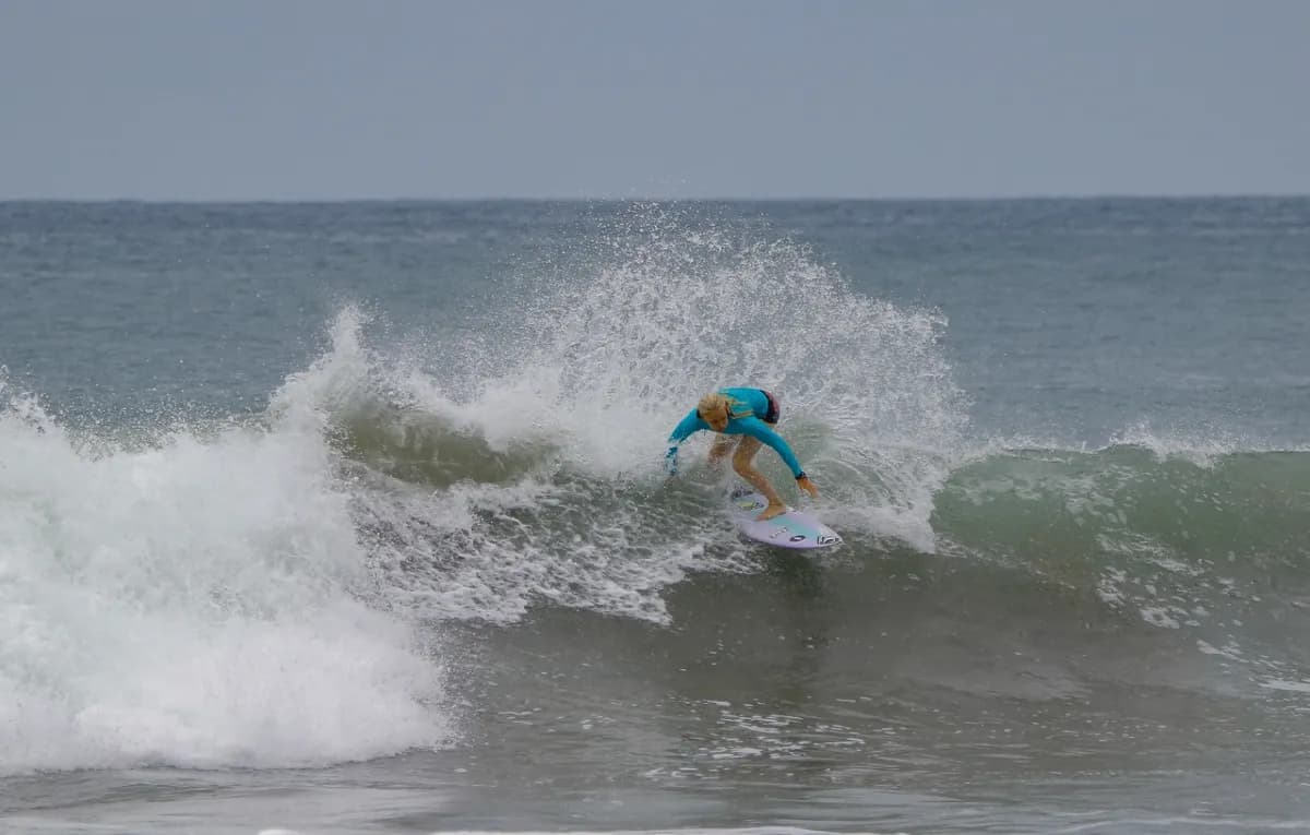 Surfer skillfully carves through a breaking wave.