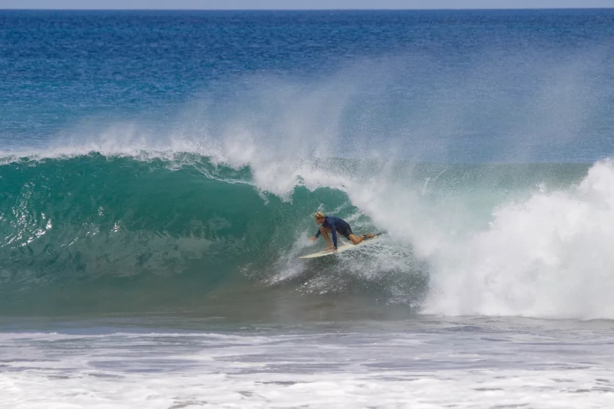 Surfer rides inside a powerful ocean barrel.