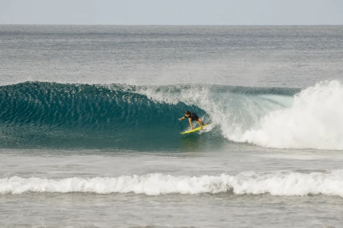 Surfer tucked into a clean right-hand barrel.