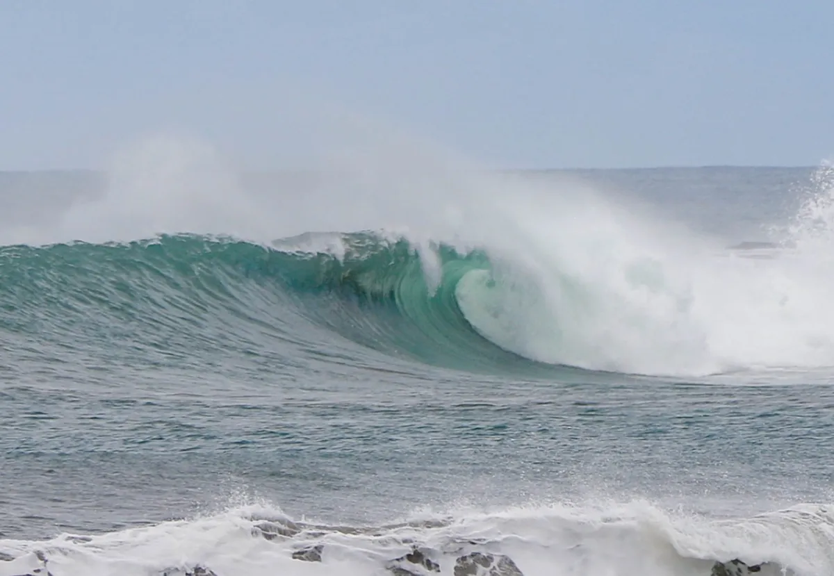 Powerful wave breaking with a barrel section offshore.