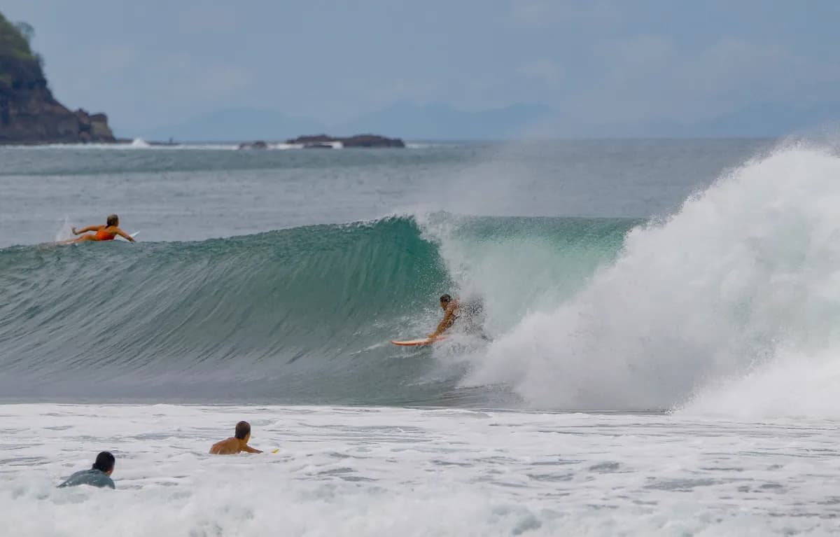 Surfer crouches inside a powerful breaking wave.