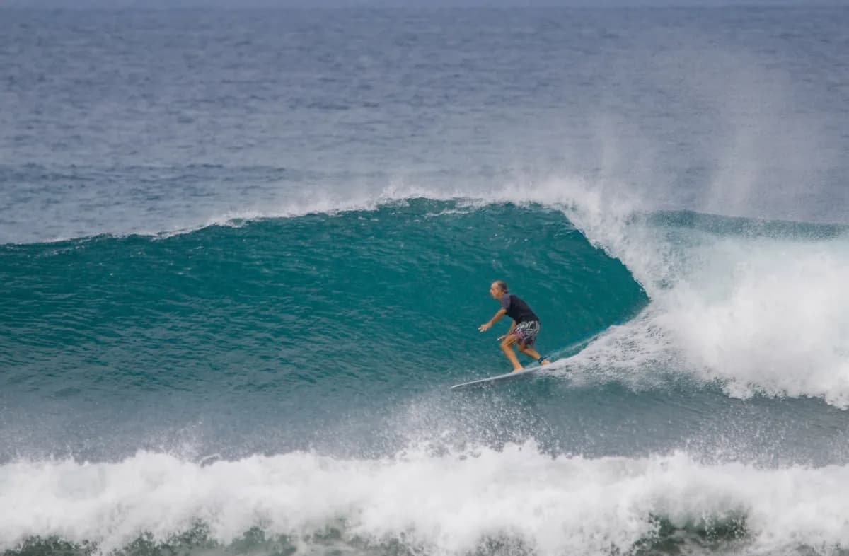 Surfer rides a perfect blue wave at Panga Drops.
