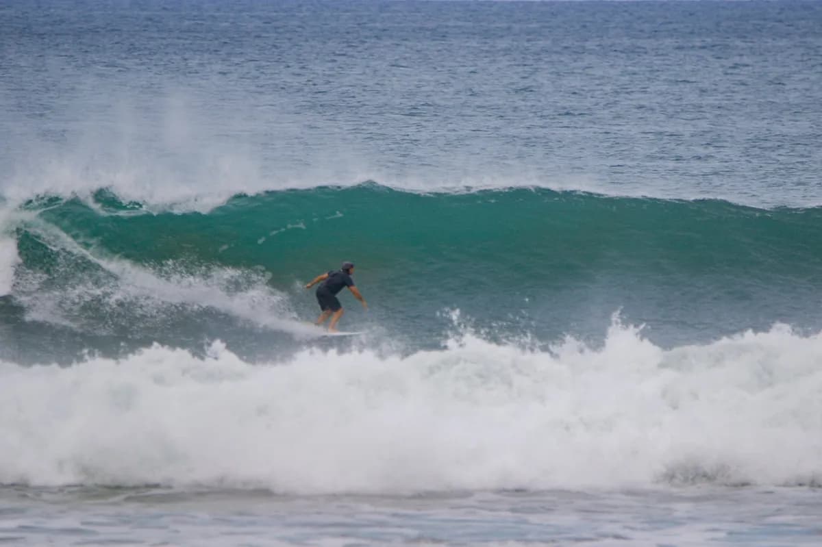 Surfer rides inside a powerful green barrel wave.