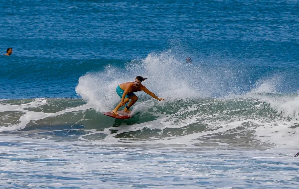 Surfer carves smoothly along the wave face.
