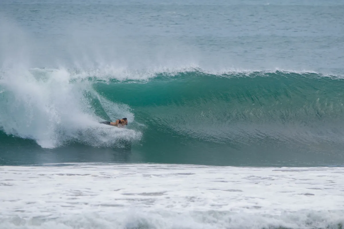 Surfer rides a hollow right-hand barrel wave.
