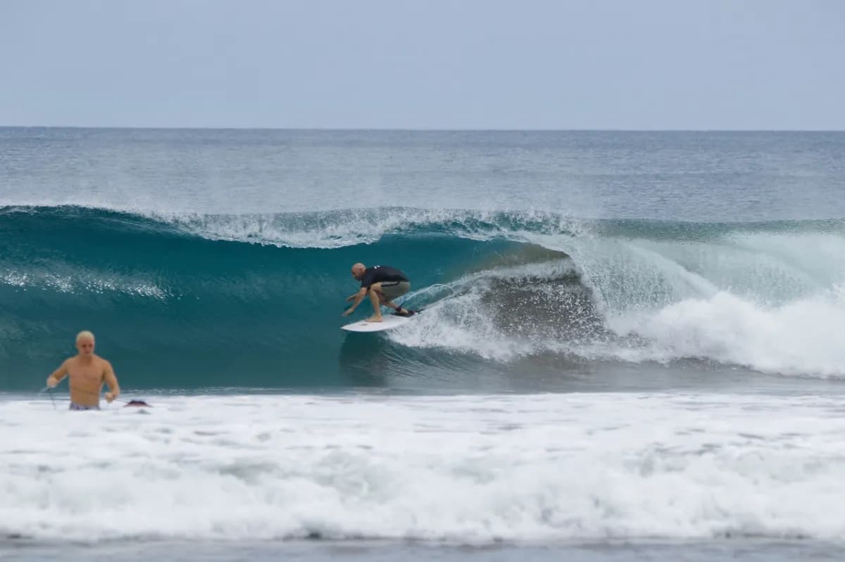 Surfer riding a clean right-hand barrel wave.