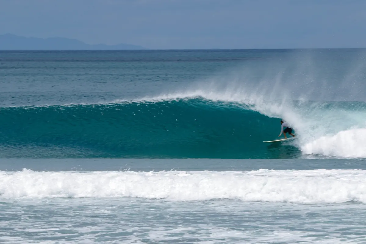 Surfer rides a smooth barrel wave with precision.