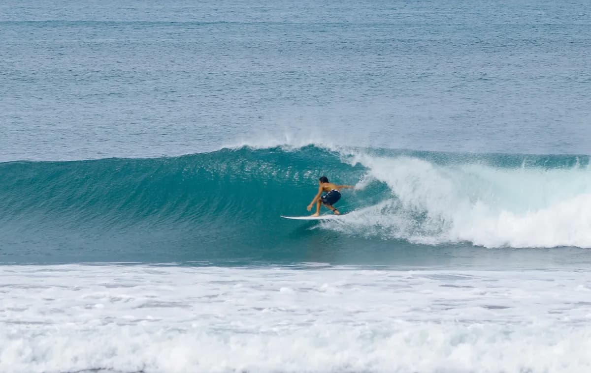 Surfer riding inside a clean, hollow barrel.