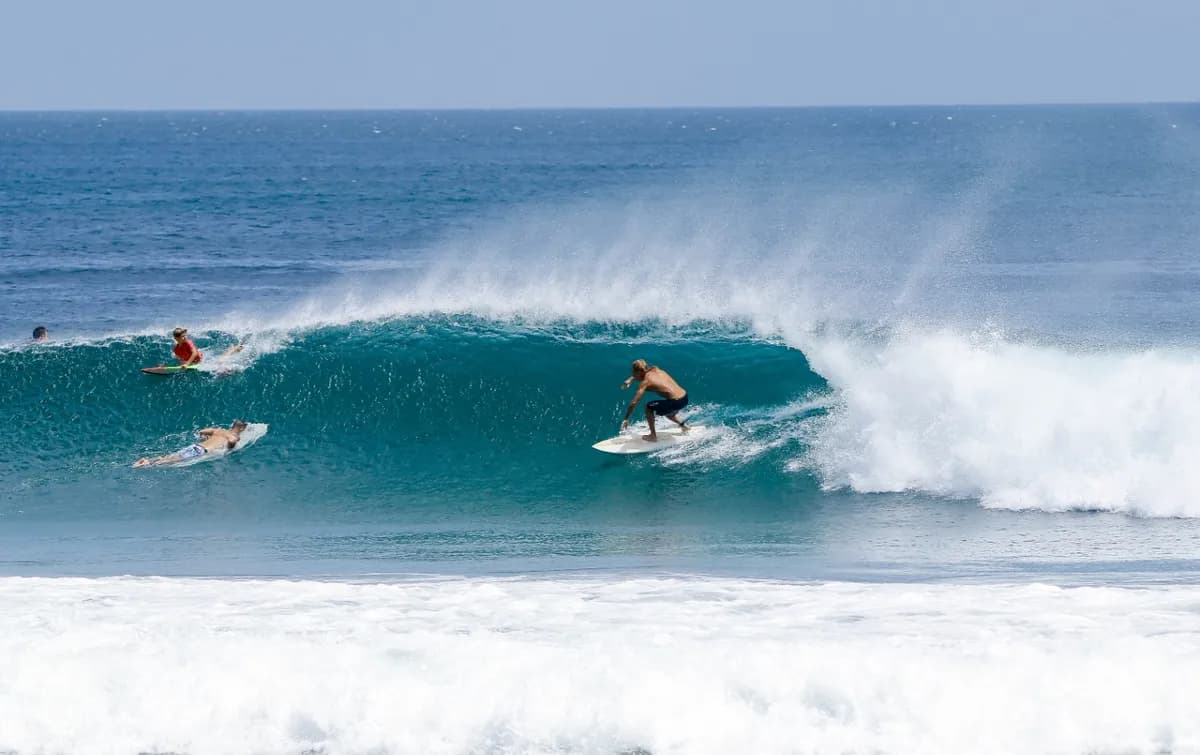 Surfer @bauti-yelos rides inside a perfect blue wave barrel.