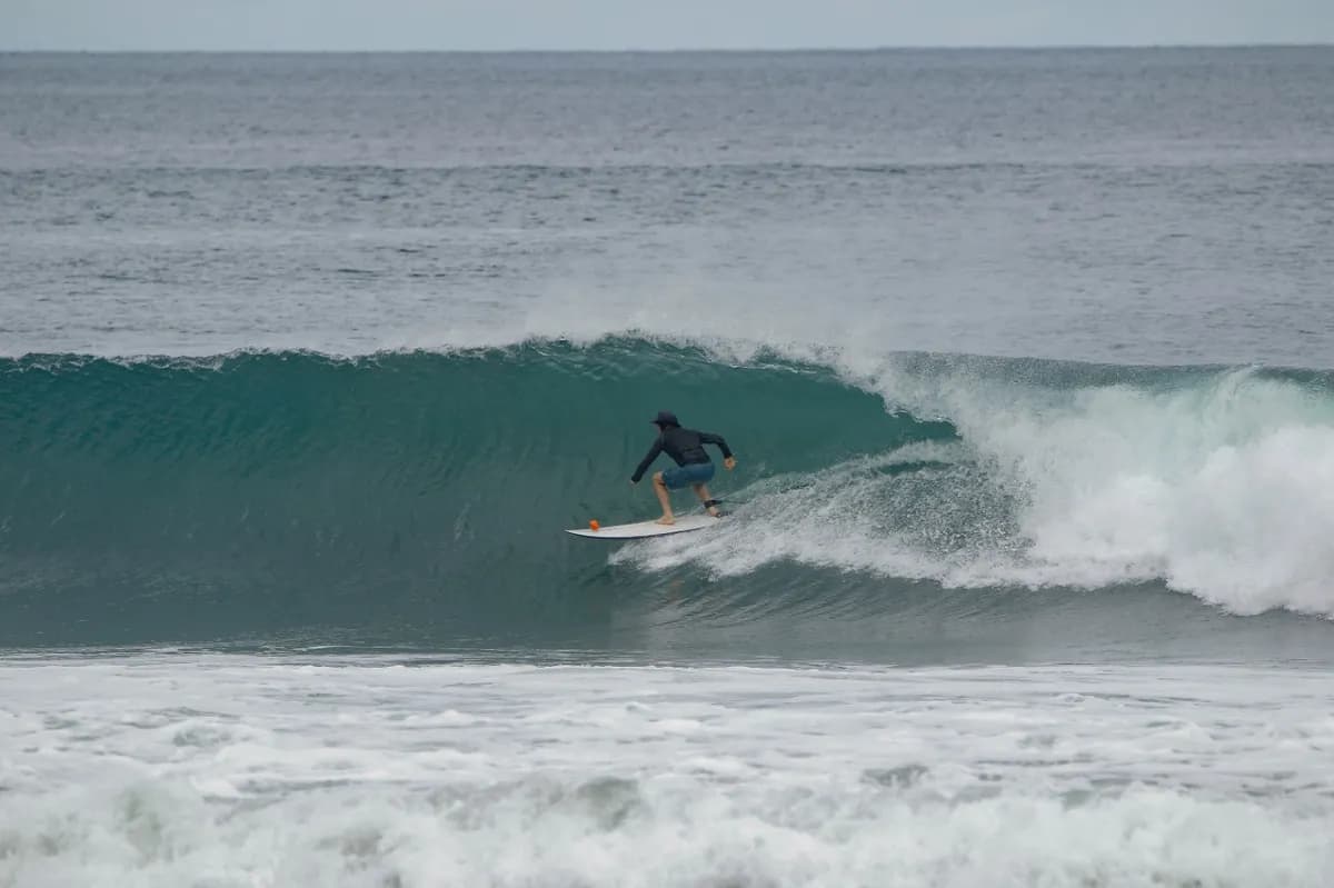 Surfer gliding smoothly inside a peeling wave.