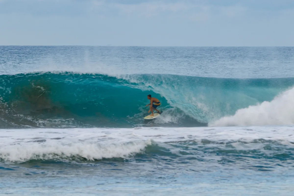 Surfer tucks into a deep barrel at Playa Colorado.