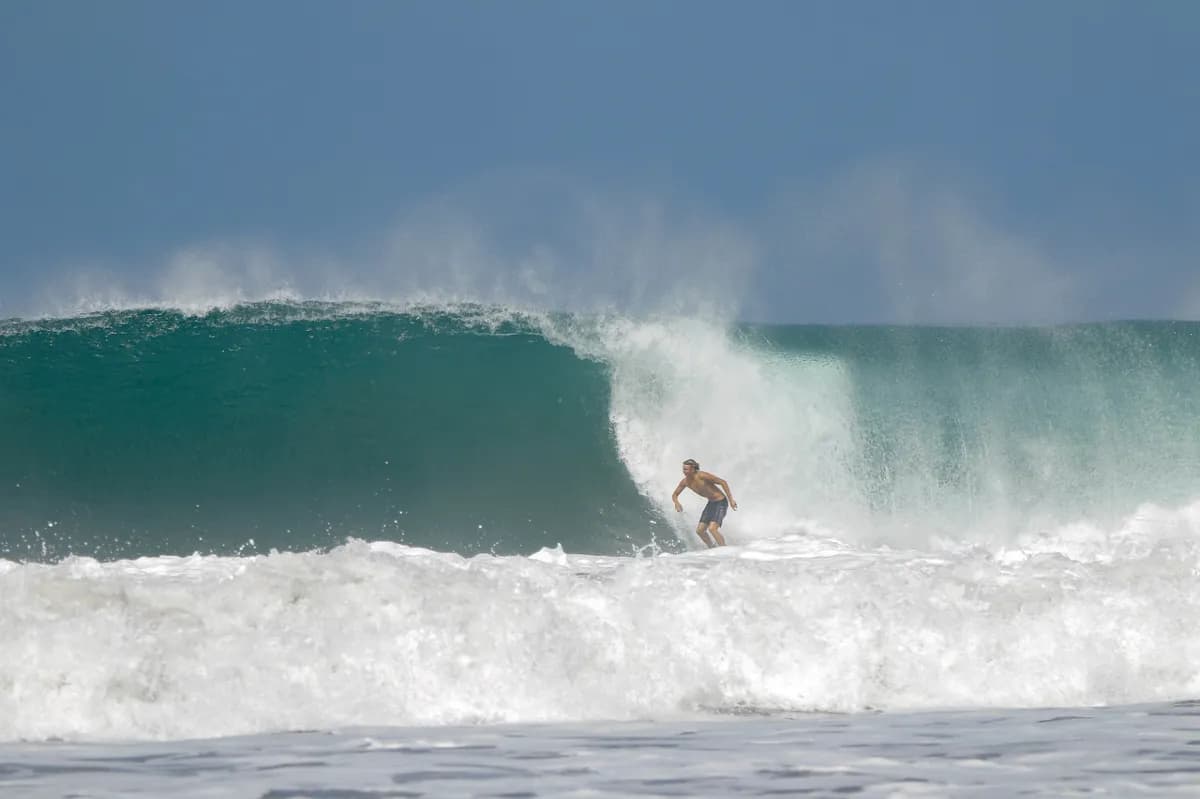 Surfer rides a powerful, hollow right-hand wave.