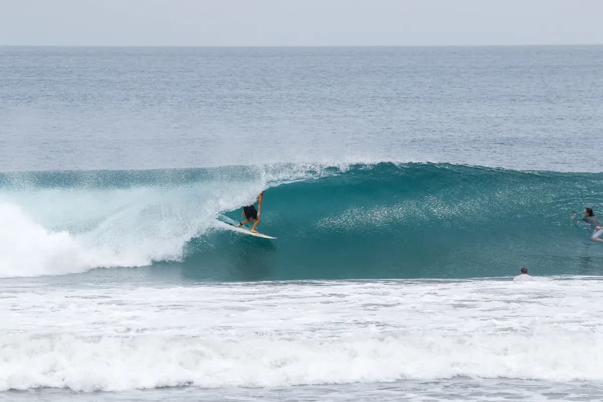 Surfer riding a perfect barrel wave, deep in the tube.