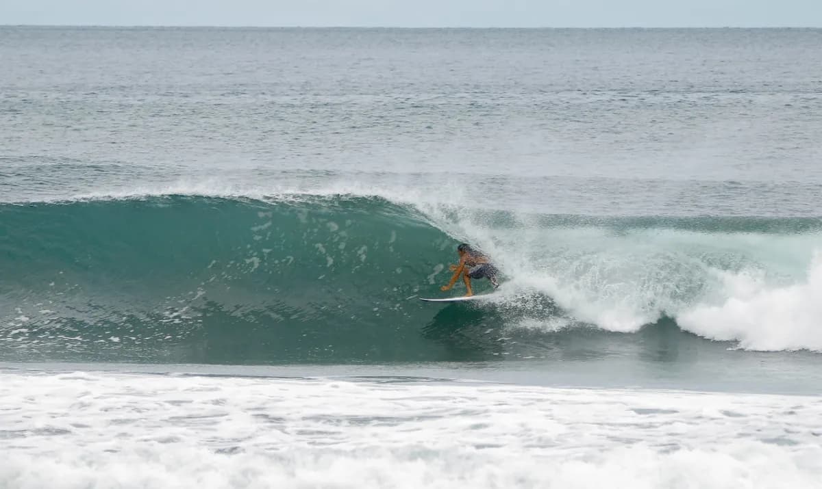 Surfer skillfully rides inside a perfect turquoise barrel.