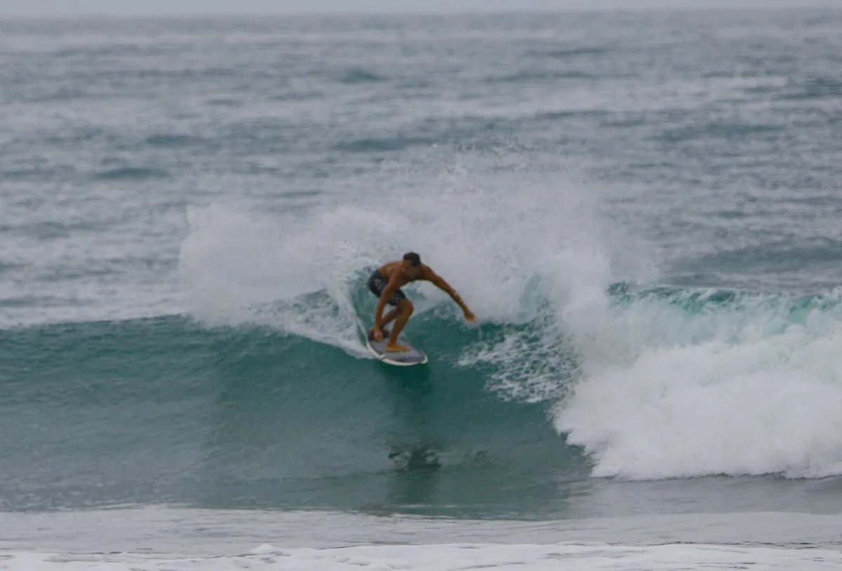 Surfer carves sharply on a smooth wave.
