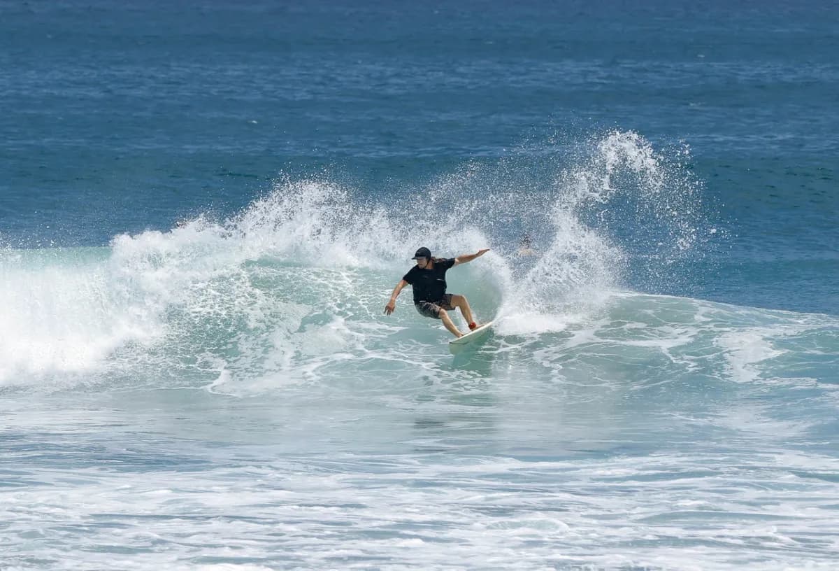 Surfer executes a stylish cutback on a breaking wave.
